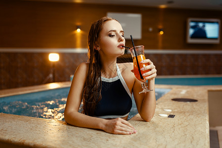 湿身魅力女在温泉沙龙里喝着饮料图片