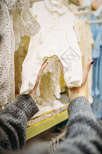 孕妇在商店中选择婴儿衣物高清图片