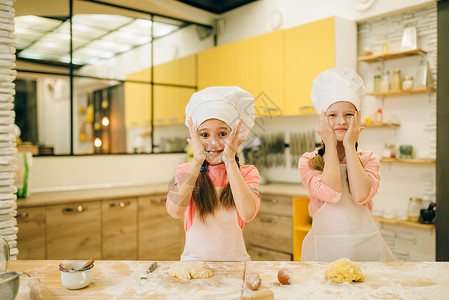 两个小女厨师用面粉抹脸图片