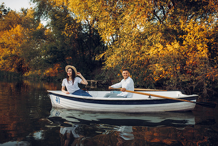 夏日宁静的湖边一对夫妇沿着河划船侧观旅行图片
