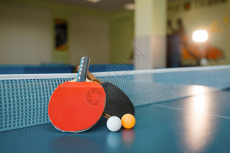 乒乓球板两个乒乓球拍放在乒乓球桌上背景