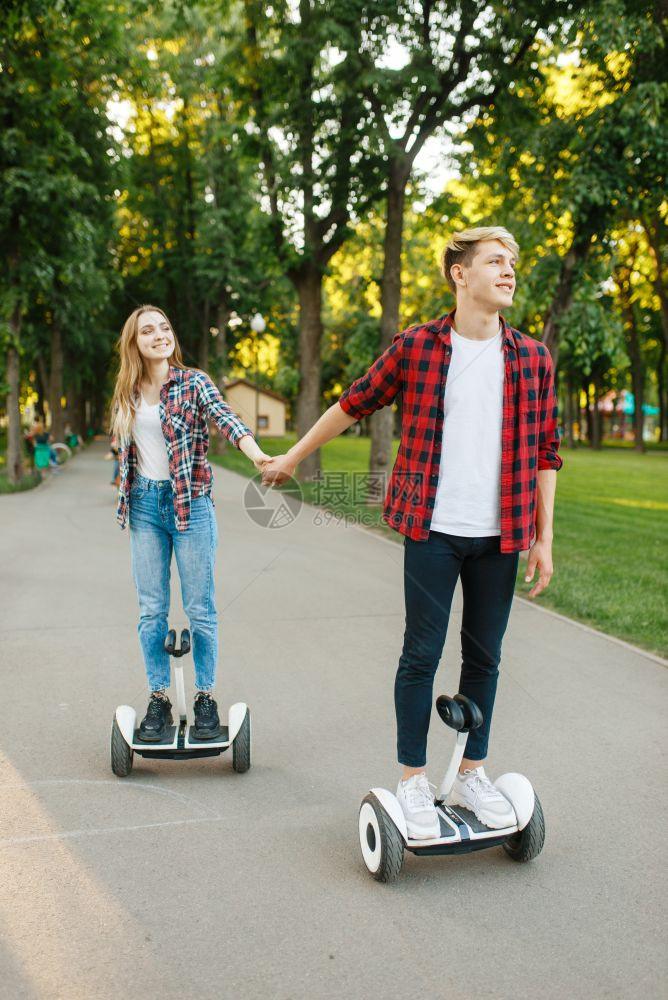 在公园使用平衡车的年轻夫妇图片