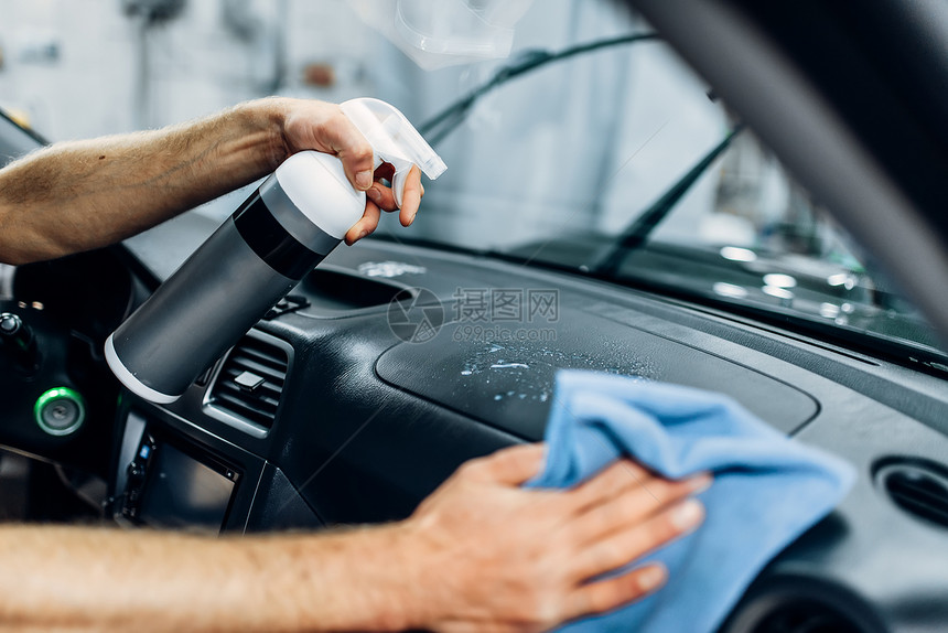 手套沙龙工人正在用刷清洗汽车内部喷洒擦粉雾图片