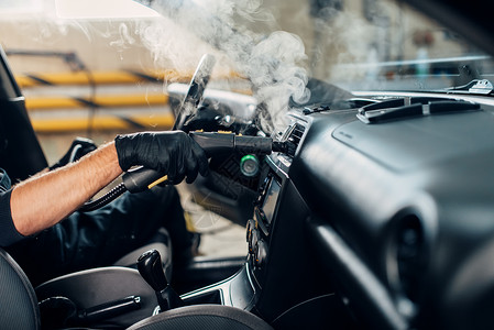 男洗车工正在使用蒸汽清洁器干洗车辆内部高清图片