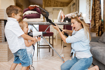 妇女小孩在家里拿着吸尘器玩得开心图片