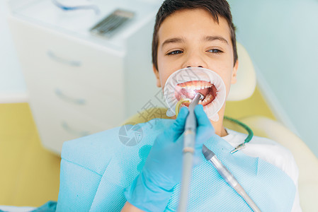 儿科牙医检查小病人的牙齿图片