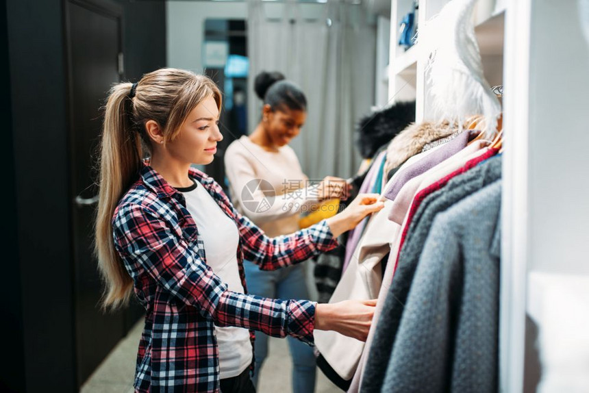 两个女朋友在服装店选择衣服购物图片