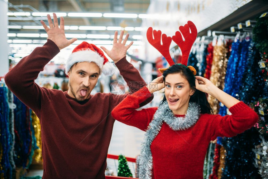 在超市带着圣诞装饰品做鬼脸的夫妻图片