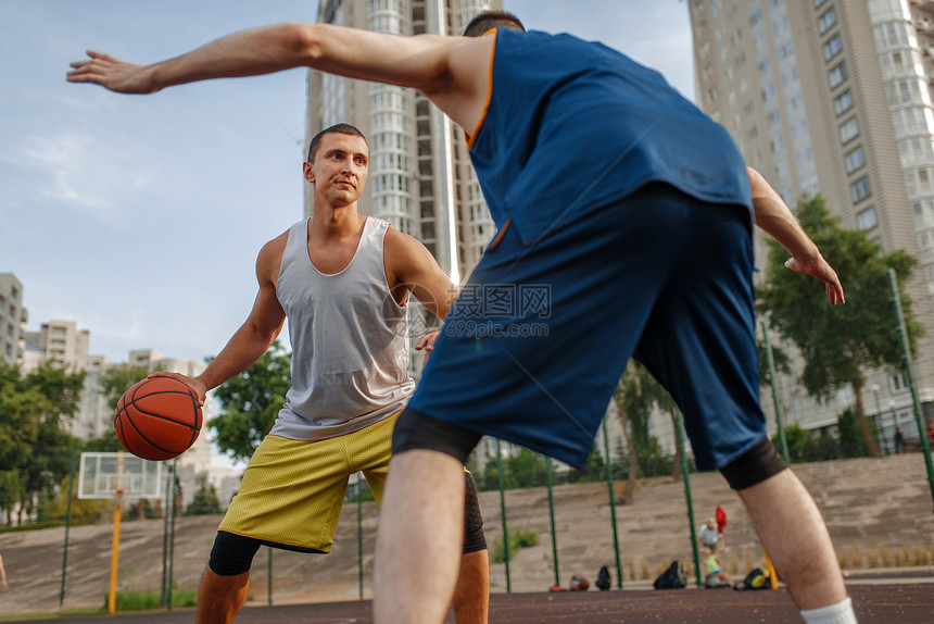 在户外球场的篮中心有两个员男运动穿服在街头足球训练中玩游戏两个球员在篮场中心打图片