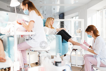 专业美容师和女顾客在温泉疗养所做脚指甲护理背景图片