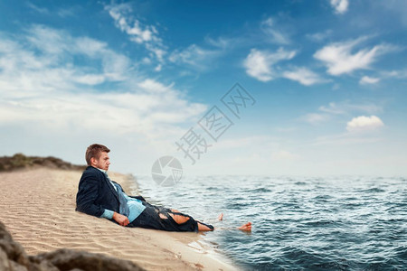 破产的男商人崩溃的躺在海滩上图片
