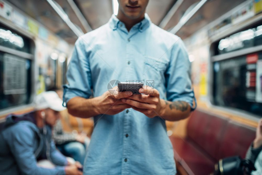 年轻人在地铁使用电话图片