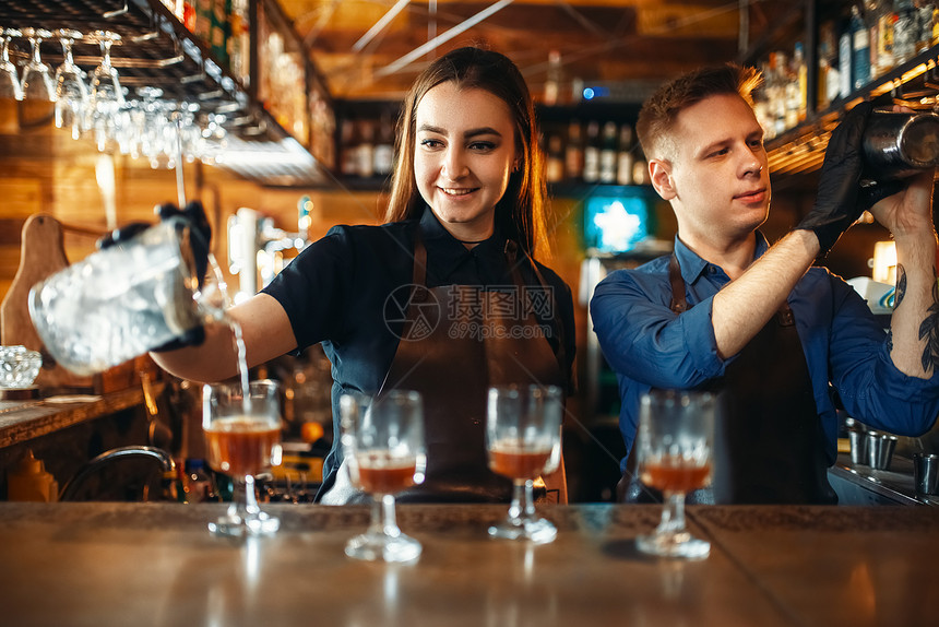 女酒保在吧台做鸡尾酒图片