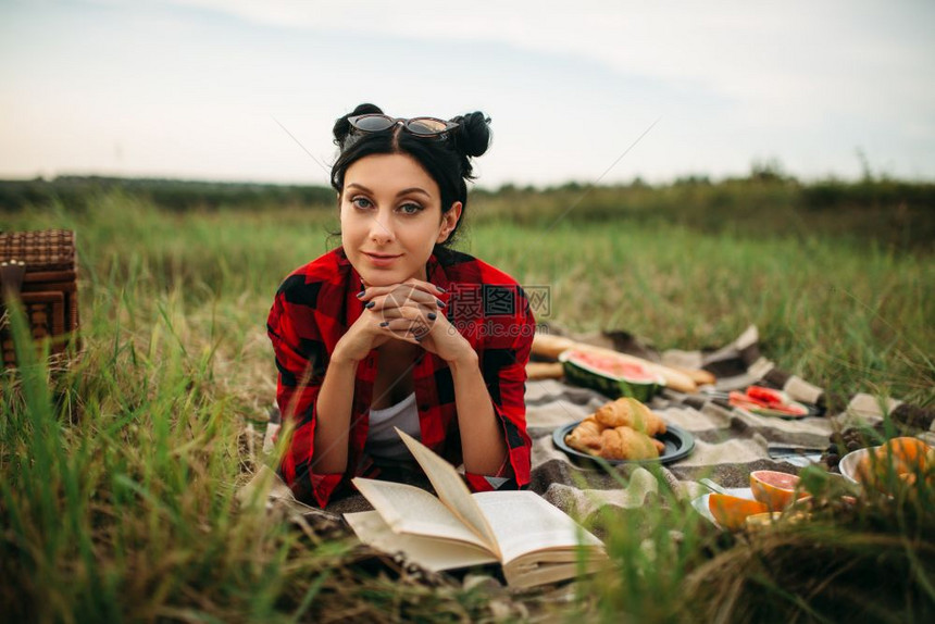 趴在草地上野餐度假的年轻女子图片