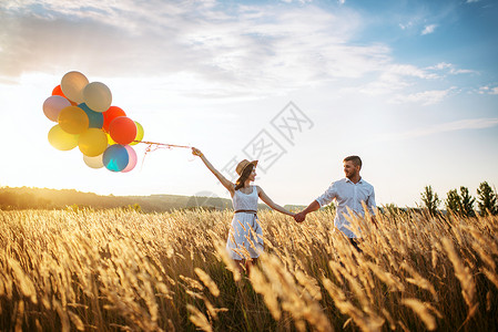 美丽的妻子手拉气球和丈夫手拉手图片