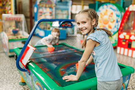 两个快乐的女孩在儿童游戏中心玩空曲棍球图片