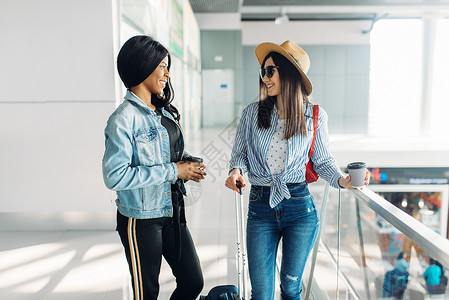 携带行李的女旅客在机场开心交谈图片