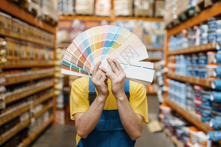 在五金商店显示彩色调盘的工作人员图片