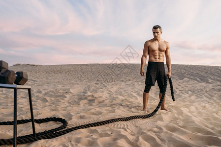 沙漠上男运动员准备拉绳锻炼图片