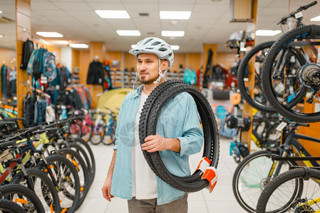 购买自行车头盔和轮胎的男子图片