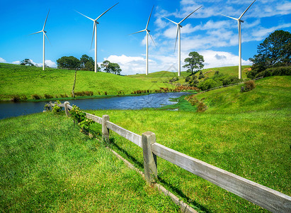夏季蓝天白云下草地上的可再生清洁能源风力涡轮机图片