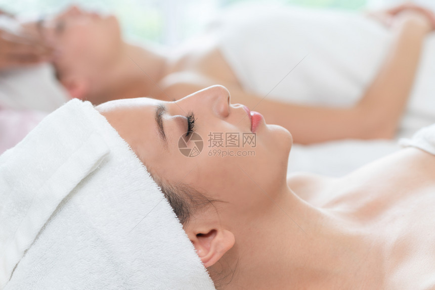 在温泉床享受头部按摩理疗的美女图片