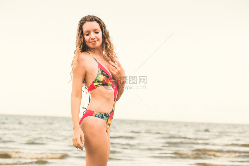 身穿泳衣的快乐年轻女子暑假在热带海滩度图片