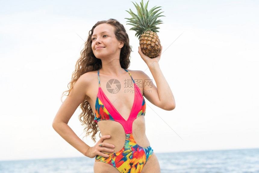 热带沙滩上穿泳衣的快乐女子图片