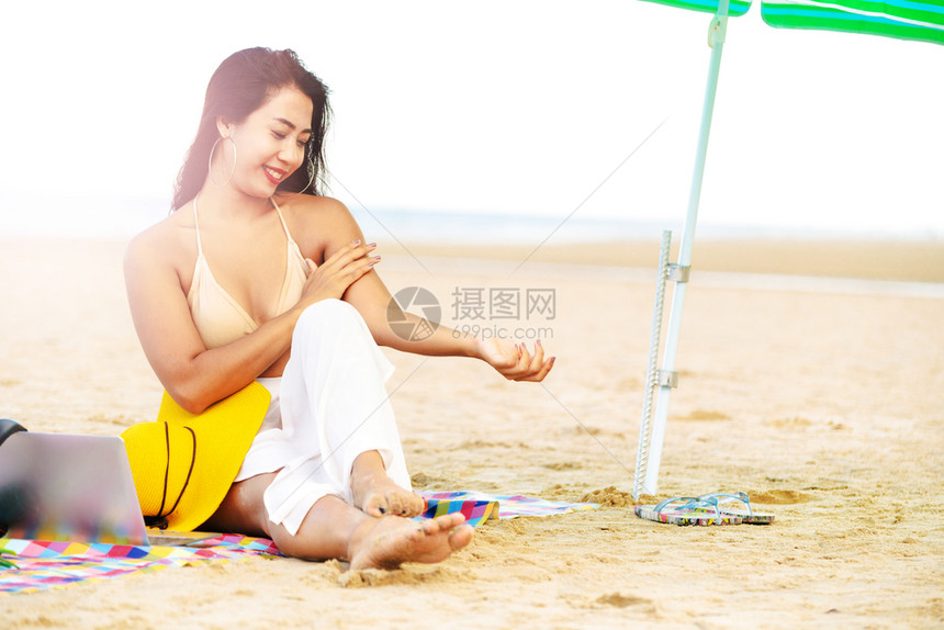 夏日坐在沙滩上的年轻女孩图片
