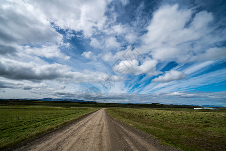 旅游乘坐汽车穿越农村地貌和草的空沙砾泥路图片