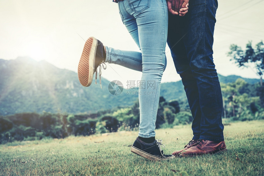 快乐的情侣站在草地上接吻图片