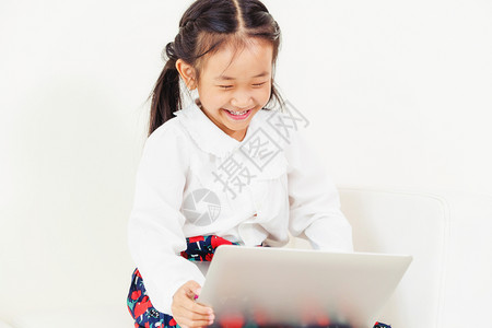 小女孩愉快的玩着平板电脑图片