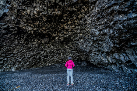 位于火山黑岩洞穴的旅行者图片