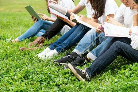 大学生们坐在草地上看书学习图片
