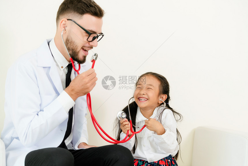 孩子在医院办公室愉快的与医生玩耍图片
