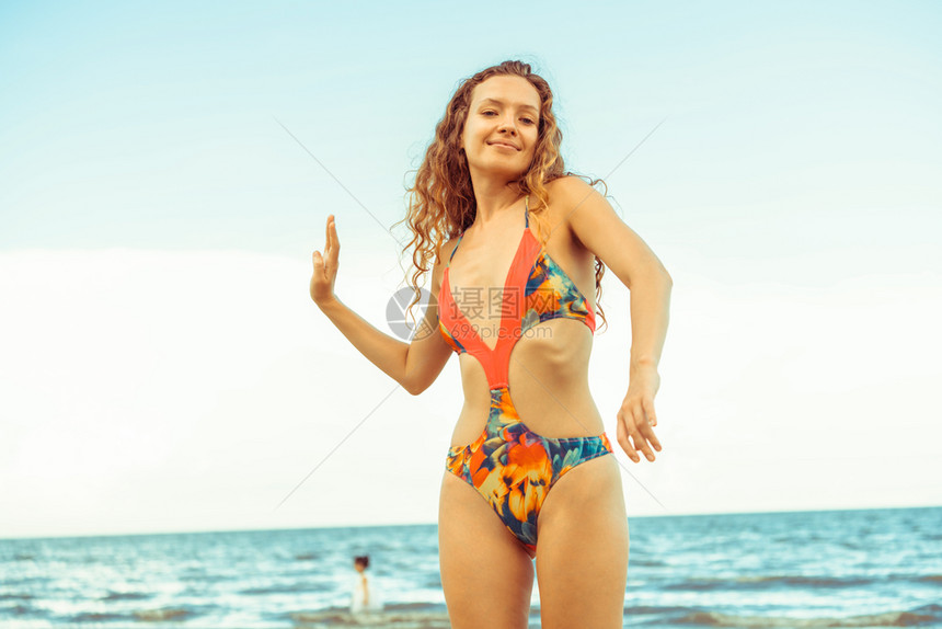 穿着泳衣的年轻美女在海滩度假图片