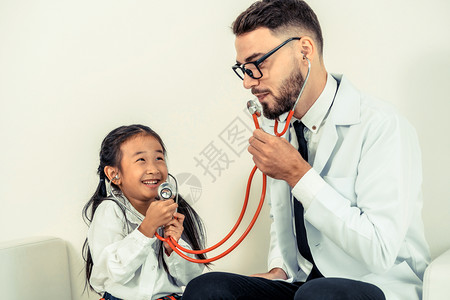 孩子在医院办公室看病与医生愉快的用听诊器对话图片