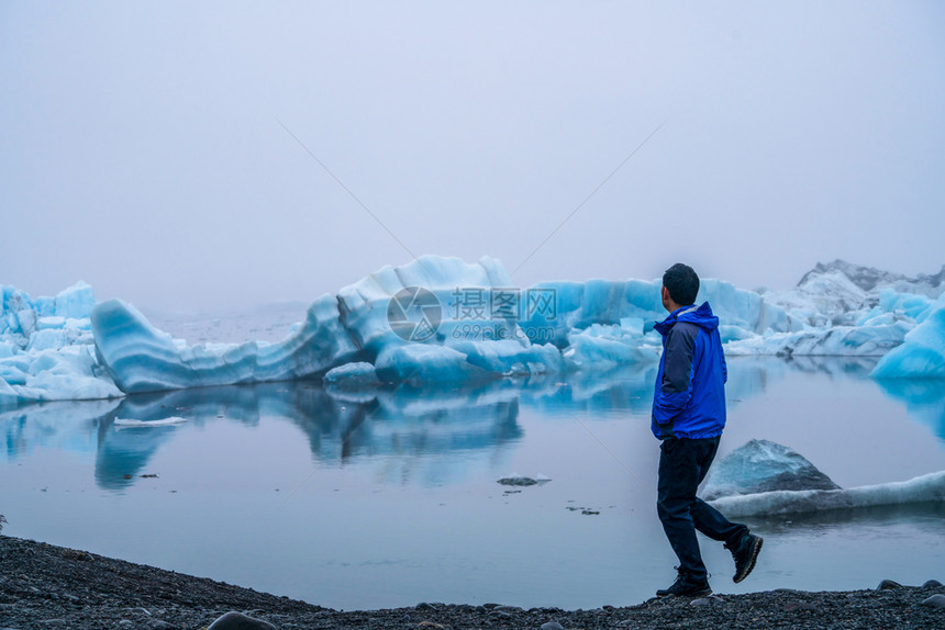 旅行者在冰川附近行走图片