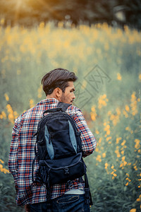 年轻男子带着背包在自然和山地的风景中旅行图片