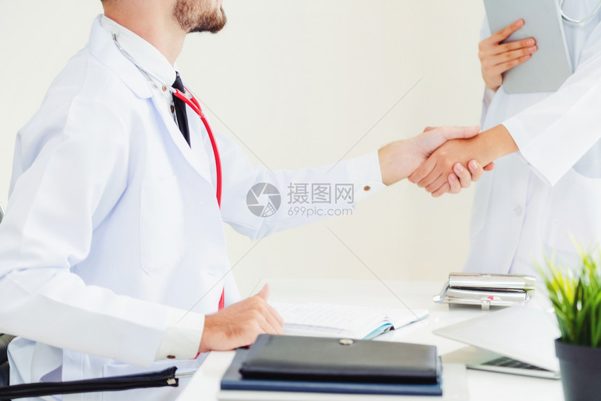医生向另一名成功的医生握手图片
