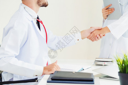 医生向另一名成功的医生握手图片