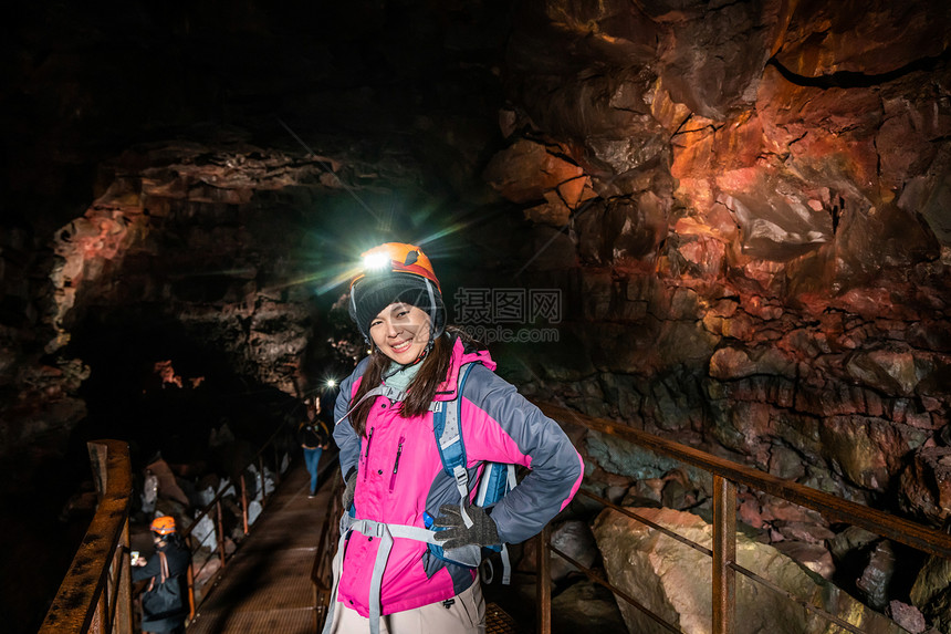 女旅行者探索冰原的熔岩隧道图片