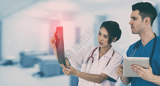 女医生在看x光片的同时与另一名医生讨论图片