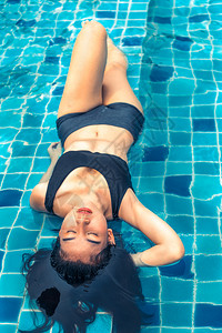 在豪华海滩度假胜地游泳池的年轻妇女图片