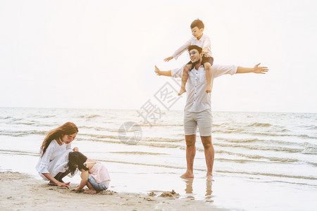 夏天热带沙滩度假的幸福一家人图片