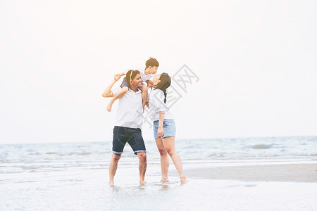 一家人开心的在海边度假妈妈亲吻着儿子图片