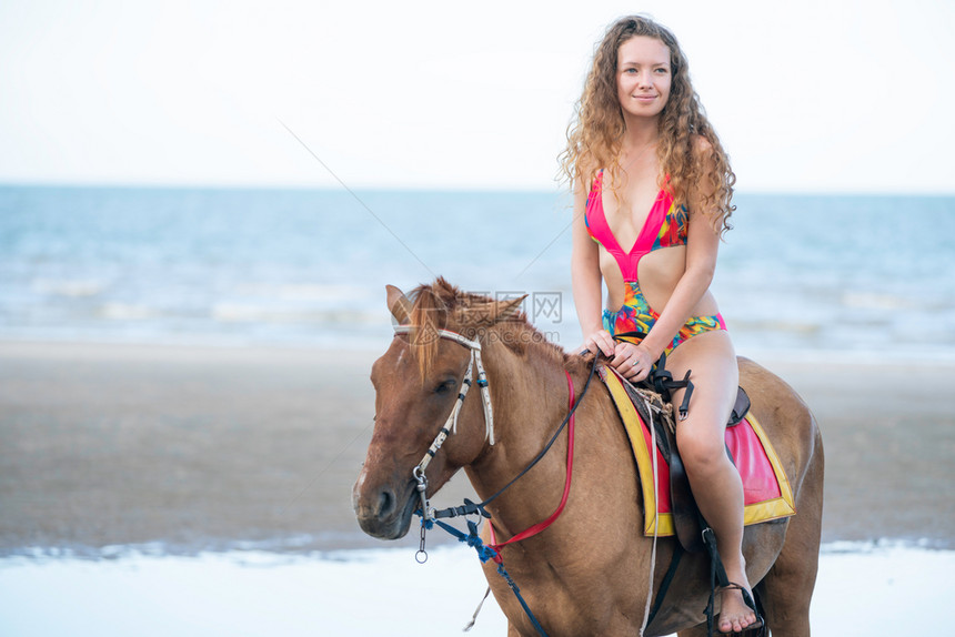 夏天在海滩骑马的时装模特图片