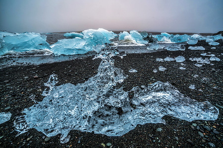 冰山在原上的钻石海滩黑沙冰冻的块被称为钻石海滩流图片