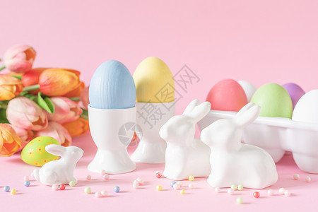 粉红色背景的鸡蛋和白色兔子装饰品图片