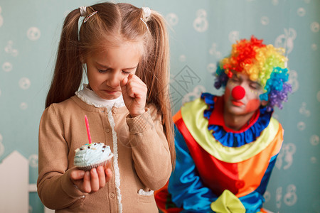 小丑生日小女孩在哭泣因为她没有时间许愿背景